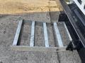 A metal ladder extension for a 2022 Freightliner M2 106 with a slatted design and a side hinge mechanism