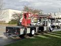 A 2010 International 4300 truck with a flatbed and a mounted hydraulic crane on the rear