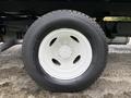The image shows a close-up of a white wheel and tire from a 2022 Ford E-450 with visible treads and a metallic hub assembly