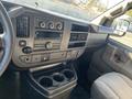 Interior view of a 2016 GMC Savana showcasing the dashboard with climate controls audio system and a console with cup holders