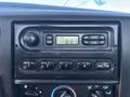 Dashboard of a 2004 Ford F-750 featuring a music radio display with buttons for tuning and selecting FM and AM stations