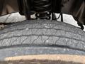 A close-up view of a worn tire on a 2009 Ford F-450 Super Duty showing cracks in the tread and visible wear patterns