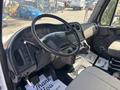 Interior view of a 2014 Freightliner M2 106 showing the steering wheel dashboard and gear shifter