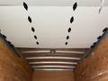 Interior view of a 2022 Ford E-450 cargo area showing a white ceiling with metal latches and wooden side walls