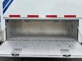 The rear storage compartment of a 1994 GMC Vandura 3500 with an open hatch revealing a clean metallic interior and no visible contents
