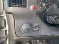 Dashboard controls of a 2011 Chevrolet Express including a headlight switch a red push button and various instrument gauges