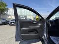 A 2018 Kia Rio5 with an open driver's door showing the interior door panel and controls