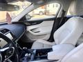 Interior of a 2020 Jaguar XE featuring a leather driver's seat a sleek console and a central touchscreen display