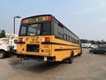 A yellow 2007 Freightliner B2 school bus with a sign on the front stating "School Bus" and caution lights on the roof