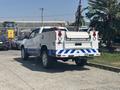 A white 2017 Chevrolet Colorado pickup truck with blue accents parked with its tailgate down and visible truck bed accessories