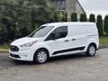 A white 2019 Ford Transit Connect van is parked with a sleek design featuring a front grille and sliding side door