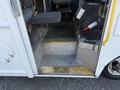A 2012 Ford Econoline showing the entrance with steps and a fire extinguisher mounted inside the vehicle