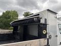 A 2015 Mitsubishi Fuso FE160 featuring a flatbed with a metal roller and a black mesh fence along the sides