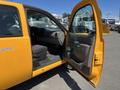 A yellow 2013 Chevrolet Silverado 1500 with its driver door open showing the interior including the seats and dashboard