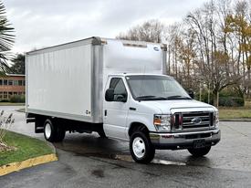 A 2019 Ford Econoline box truck with a white cargo area and a black front grille is parked on a roadway