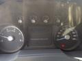 Dashboard of a 2011 Ford F-750 showing gauges for RPM speed and fuel with buttons and warning lights