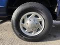 Close-up of a silver alloy wheel with a blue rim on a Hankook tire featuring a distinctive tread design showcasing the 2011 Ford Econoline's wheel assembly