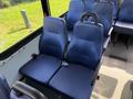 Two blue fabric seats inside a 2020 Chevrolet Express van with a seatbelt clipped into one of the seats