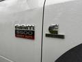 Close-up of a 2012 Dodge Ram 5500 badge featuring the words RAM 5500 HEAVY DUTY and CUMMINS TURBO DIESEL with raindrops on the surface