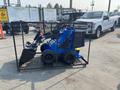 A blue 2025 AGT MX-MZW14 compact loader with a bucket attachment parked in a metal enclosure with wheels and a sturdy frame