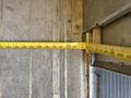 A yellow measuring tape showing a measurement of 198 inches next to a metal edge of a vehicle door