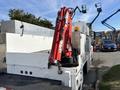 A white 2006 International 4300 truck with a red crane mounted on the bed