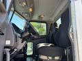 Interior view of a 2020 Peterbilt 330 truck featuring a driver's seat and steering wheel with an ergonomic design