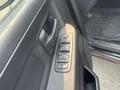 A close-up view of the driver's side door panel of a 2015 RAM 1500 featuring power window controls and door handle
