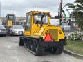 A yellow 2004 Bombardier SW48 utility vehicle with tracks and a rear cab facing away, featuring a prominent rear light and bumper design