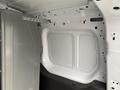 Interior of a 2017 Ford Transit Connect showing a metal panel and an empty cargo space with white walls and minimal features