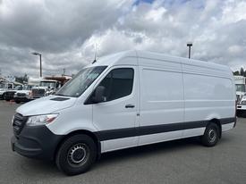 A 2025 Mercedes-Benz Sprinter van in a white exterior with a gray lower section and black wheels positioned at an angle