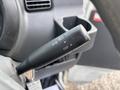 A close-up of the control stalk in a 2010 Daihatsu Hijet featuring indicator and light controls with an off position