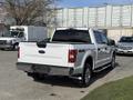 2018 Ford F-150 pickup truck in white with a four-wheel drive badge visible on the back and chrome accents on the rear bumper