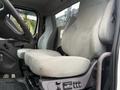 Interior view of a 2019 Freightliner M2 showing two gray fabric seats positioned side by side with controls on the center console