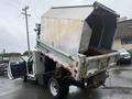 A 2011 Dodge Ram 5500 with a raised dump bed showing the interior of the truck and the hydraulic mechanisms used for lifting the bed
