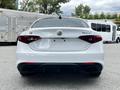 A white 2023 Alfa Romeo Giulia viewed from the rear showcasing its sleek design and distinctive taillights