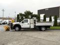 A 2013 Ford F-450 Super Duty with a flatbed and snow plow attachment parked on a lot
