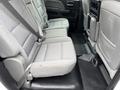 The interior of a 2015 GMC Sierra 1500 showing a rear seating area with three fabric seats and seatbelts arranged neatly in the cabin.