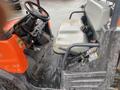 Interior view of a 2010 Kubota RTV 900 featuring a driver's seat steering wheel and control panel with various levers and gauges