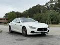A 2016 Maserati Ghibli in white parked at an angle with red brake calipers and a sleek design
