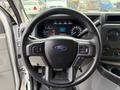 Steering wheel of a 2022 Ford E-450 featuring a Ford logo and control buttons on either side