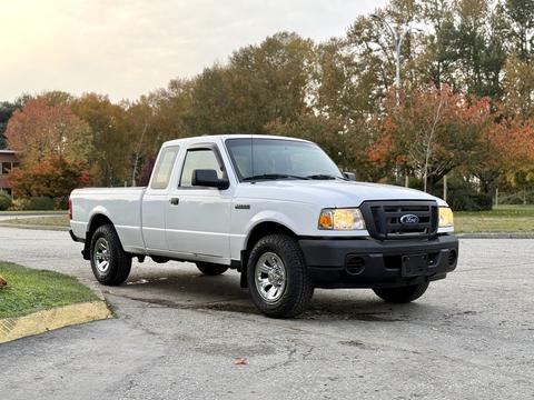 A silver 2011 Ford Ranger parked with a two-door cab and black bumpers featuring chrome wheels and a noticeable front grille
