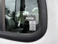 A white 2021 Freightliner M2 106 truck with a visible inspection sticker on the window displaying months and a certificate of approval