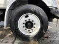 A close-up of the wheel of a 2012 International DuraStar 4300 featuring a white rim and a large black tire with visible tread marks and lug nuts