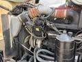 A close-up view of the engine compartment of a 1996 Kenworth T800 showcasing various mechanical components including hoses a compressor and a coolant reservoir