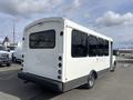 A white 2018 Chevrolet Express bus with black detailing and large windows, featuring a boxy shape and a rear ramp for accessibility