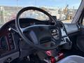 Interior view of a 2011 Freightliner M2 106 cab featuring a black steering wheel and control panel with various gauges and a mounted display screen