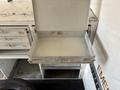 An open metal drawer from a utility vehicle's storage compartment with a flat bottom and a smooth surface