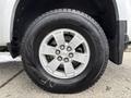 Close-up of a silver wheel and tire of a 2018 Chevrolet Colorado showcasing a five-spoke alloy rim with a Chevrolet bowtie emblem on the center cap