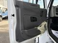 A close-up view of the door panel of a 2012 International DuraStar 4300 featuring a gray design with a handle and a small window opening